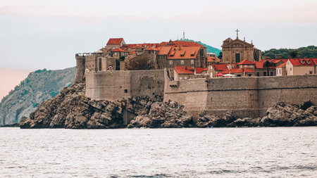 Dubrovnik old city harbor view with city walls and red rooftops from boat coming from Lokrumのeditorial素材