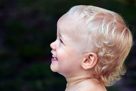 Portrait about a happy little child on green background.の写真素材