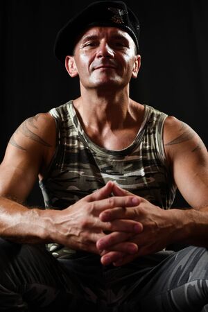 The man in military clothes with beret is sitting.の写真素材