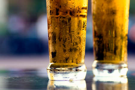 Two cold lager light beers on table on blue background.の写真素材