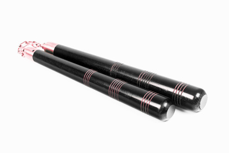 Black nunchaku, the asian weapon is isolated on white background.の写真素材