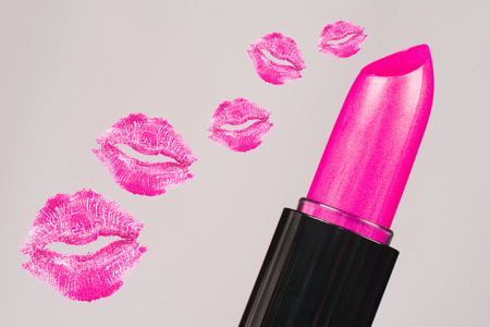 Pink lipstick and pink mouths, kisses are on gray background.の写真素材
