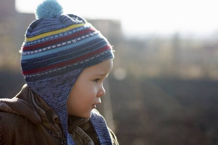 The little child in cap is outdoors.の写真素材