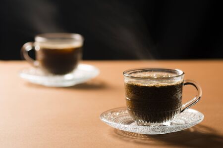 Two cup of hot coffees on table on black background.の写真素材