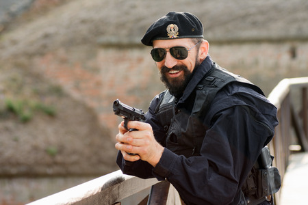 The smiling soldier in military uniform is holding a gun.の写真素材