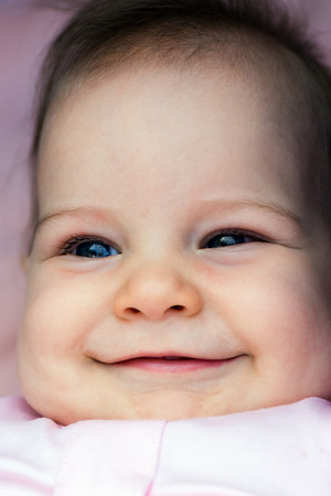 Close-up portrait of five months old smiling baby girl.