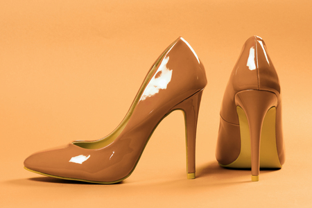 Sexy beige high heels shoes are on beige background.の写真素材
