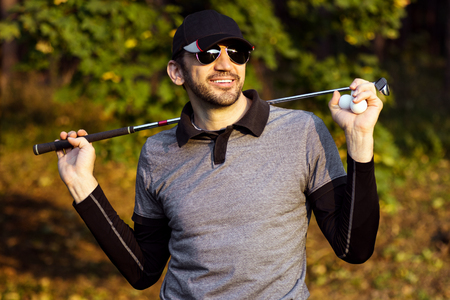 Portrait of smiling handsome confident golfer outdoors in nature.の写真素材