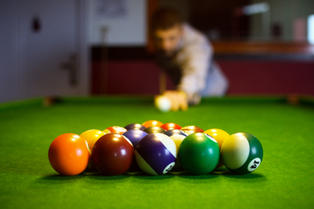 The colorful billiard or pool balls for snooker game are on green billiard table for starting the...