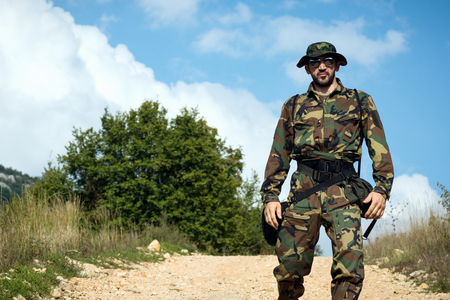 Man in military uniform is in nature outdoors, adventure concept.の写真素材