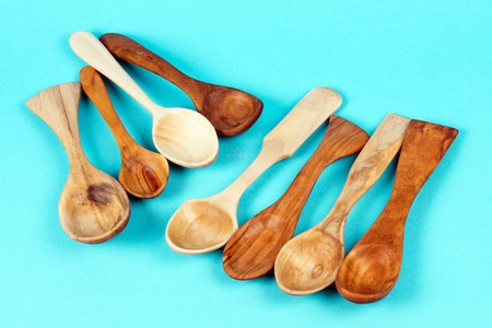 Different handmade wooden spoons are on turquoise background.の写真素材