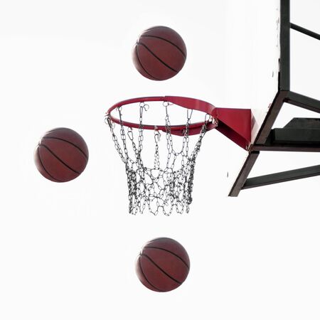 Three basketball balls are flying in the air to basket on white background, basketball sport concept.の写真素材
