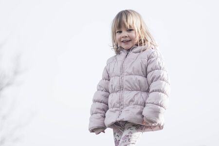 Child portrait of cute trendy little girl in jacket on white background outdoors.の写真素材