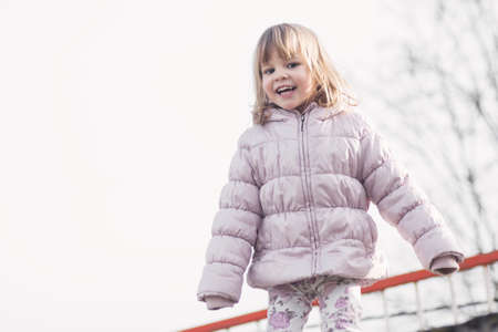 Smiling cute little girl in warm jacket or warm clothing at winter.の写真素材