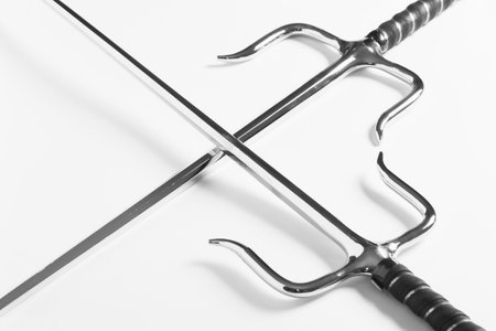 Pair of sai weapon for martial arts in X shape on white background.