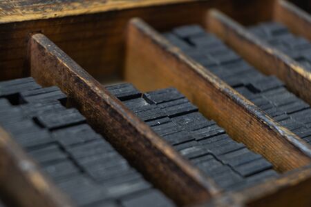 Printing press letter blocks in a wooden shelf.の写真素材