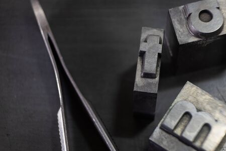 Three types of old printing with tweezers for placement, on the base for mountingの写真素材