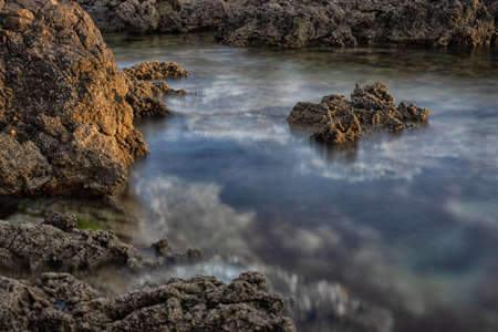 Sea water textures and rocks at sunrise. Spring time. Selective focus.