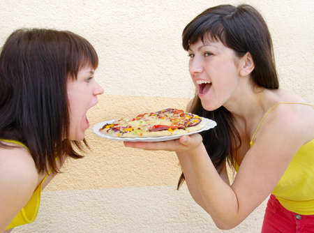 Two young woman eatingの写真素材