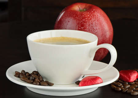 Cup of  coffee, apple  and heart shaped chocolate candy の写真素材