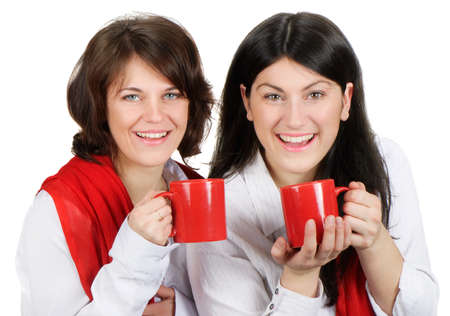 Two happy smiling young women drinking teaの写真素材