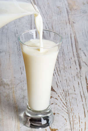 Pouring  milk from jug into  glassの写真素材