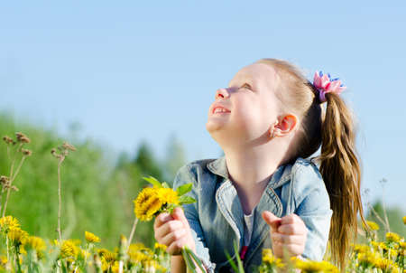 little girl with dandelions  outdoors in summerの写真素材