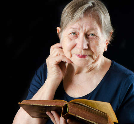 Elderly smiling woman with book