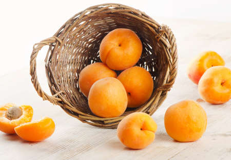 Fresh apricots in the basket on a wooden tableの写真素材