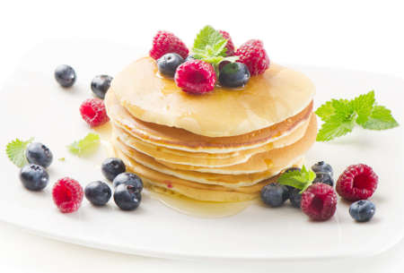 pancakes with raspberries and blueberies isolated on whiteの写真素材