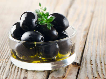 Black olives on a wooden tableの写真素材