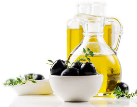 Olive oil and black olives isolated on whiteの写真素材