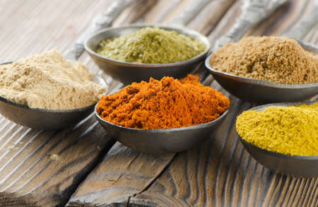 Assortment of powder spices on spoonsの写真素材