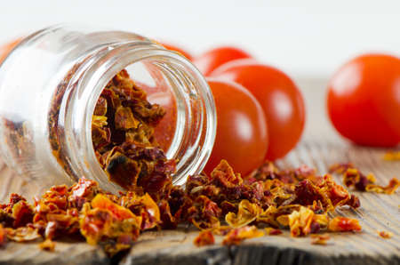 Dried and fresh  tomatoes on  wooden tableの写真素材