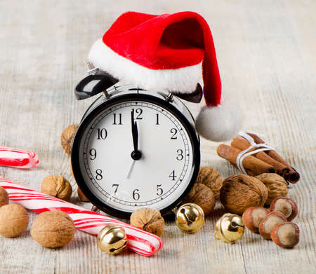 Alarm clock with Santa hat  on a wooden tableの写真素材