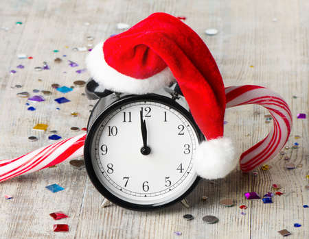 Alarm clock with Santa hat  on wooden table