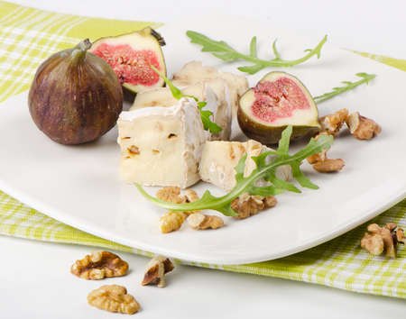 Cheese  and figs on white plateの写真素材