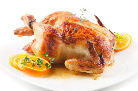 Roasted chicken on white plate with orangeの写真素材