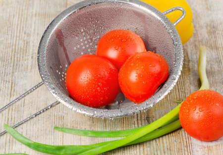 Fresh vegetables in metal colanderの写真素材