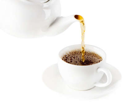Tea being poured into tea cup isolated on a white backgroundの写真素材
