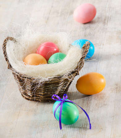Easter eggs in the basket on a wooden tableの写真素材