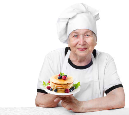 Senior woman  with pancakes isolated on whiteの写真素材