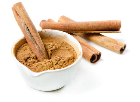 Cinnamon sticks and meal isolated on white. Selective focusの写真素材