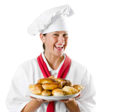 Young woman chef holding a plate with pies isolated on whiteの写真素材
