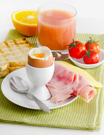 Healthy breakfast - boiled egg  with ham and juiceの写真素材