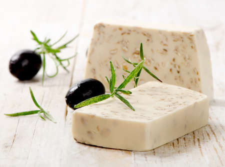 Homemade Soap with olives and herbs on a wooden tableの写真素材