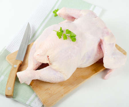 Whole raw chicken with fresh herbsの写真素材