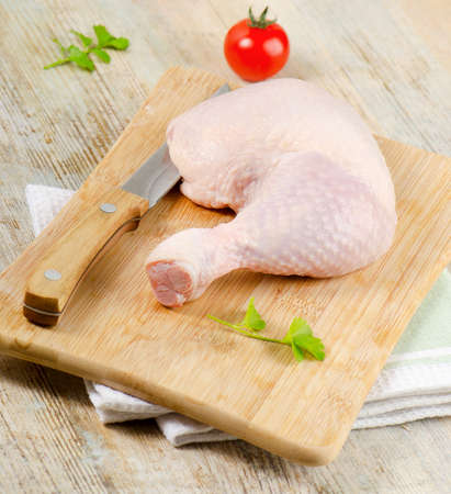 Chicken leg on a wooden tableの写真素材