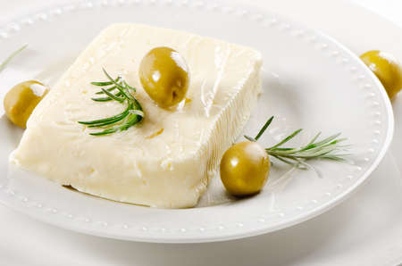 Fresh feta cheese with green olives and herbsの写真素材