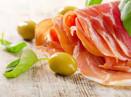 Slices of cured ham on a wooden tableの写真素材